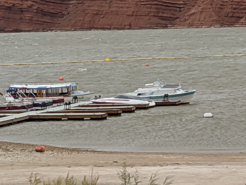Slide: The Image of Tour boats docked at a marina on a windy day, red cliffs in the background. - 45
