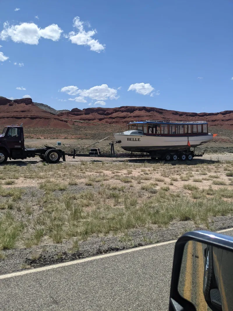 Slide: The Image of Truck towing 1987 Custom tour boat on trailer in desert landscape. - 46