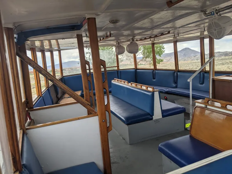 Slide: The Image of Interior of a 1987 custom tour boat with blue seating and wooden accents. - 9