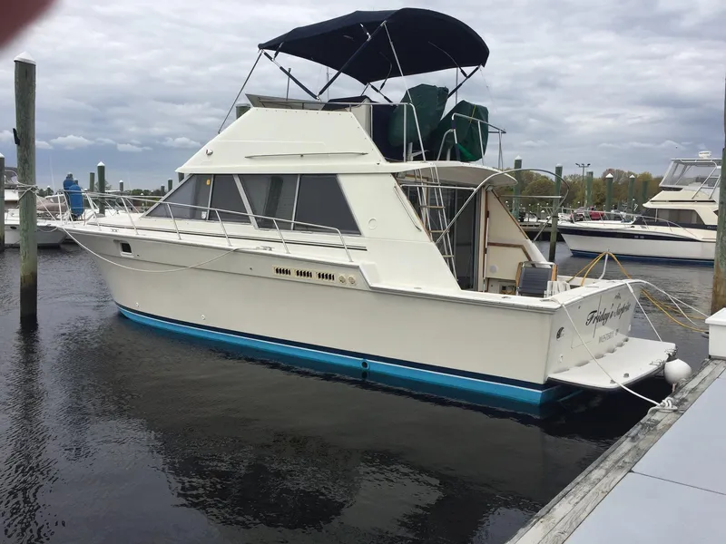 The Image of 1988 Silverton 40 Convertible yacht docked at marina under cloudy sky. - 0