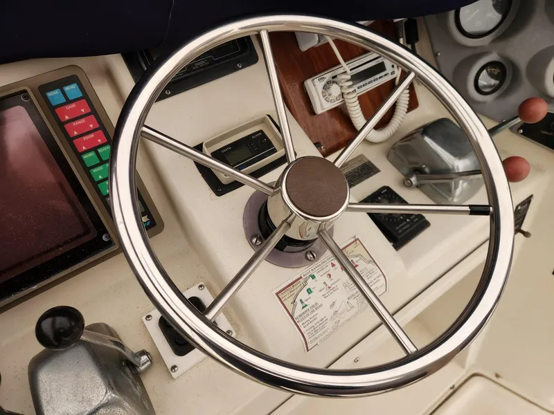 Slide: The Image of Steering wheel and controls of a 1988 Silverton 40 Convertible boat. - 10