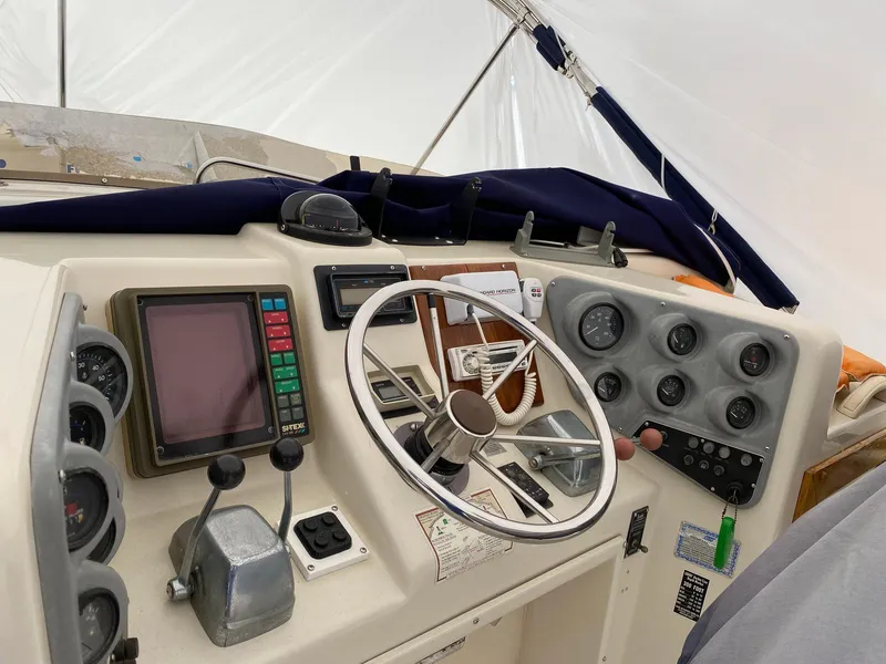 Slide: The Image of 1988 Silverton 40 Convertible boat dashboard with steering wheel and navigation instruments. - 13