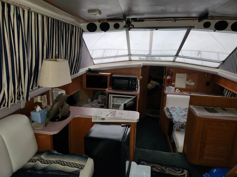 Slide: The Image of Interior of a 1988 Silverton 40 Convertible yacht with striped curtains and cozy furnishings. - 16