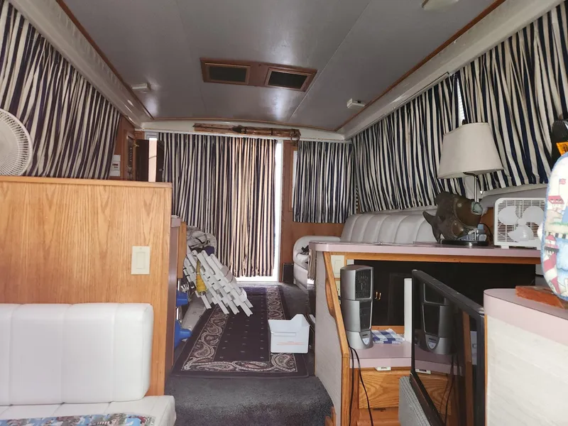 Slide: The Image of Interior of a 1988 Silverton 40 Convertible boat with striped curtains and wooden furnishings. - 19