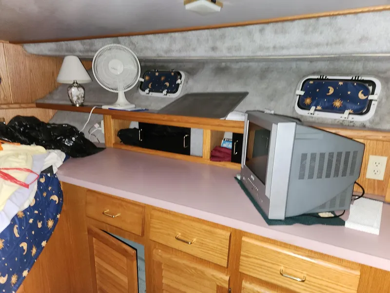 Slide: The Image of 1988 Silverton 40 Convertible cabin interior with TV, fan, and storage cabinets. - 22
