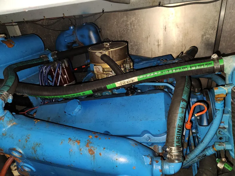 Slide: The Image of Engine compartment of a 1988 Silverton 40 Convertible boat, featuring blue components and hoses. - 26