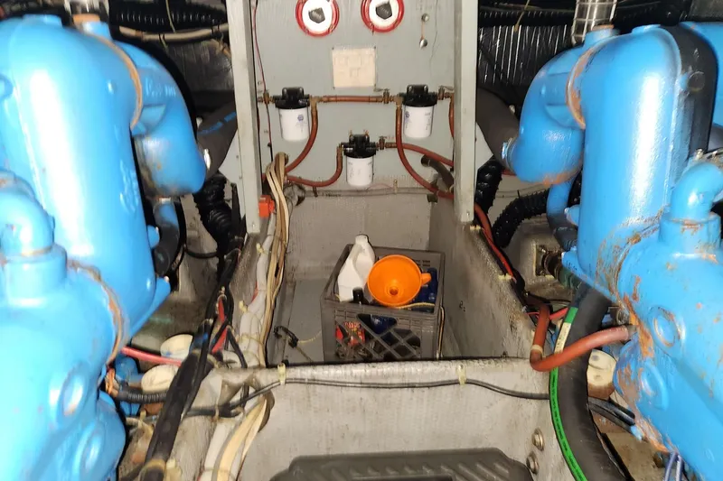 Slide: The Image of Engine room of a 1988 Silverton 40 Convertible boat with blue machinery components. - 27