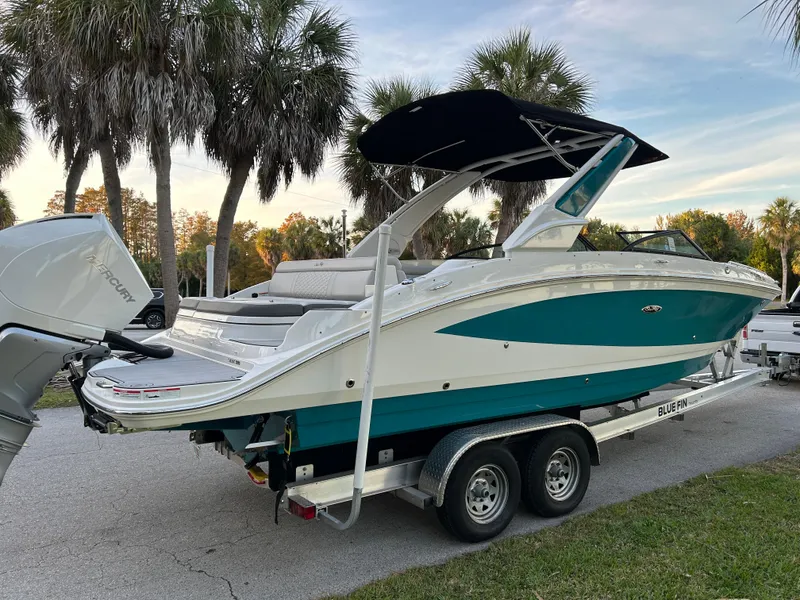Slide: The Image of 2022 Sea Ray SDX 270 Outboard boat on a trailer with palm trees in the background. - 0