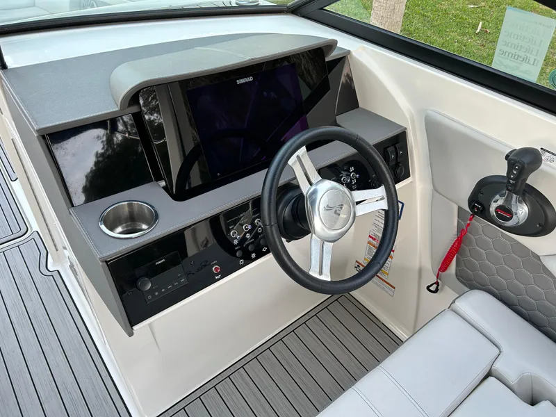 Slide: The Image of 2022 Sea Ray SDX 270 Outboard helm with steering wheel and control panel. - 23