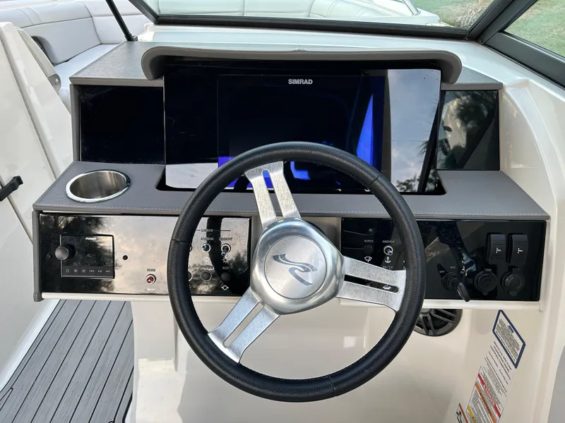 Slide: The Image of 2022 Sea Ray SDX 270 Outboard helm with steering wheel and control panel. - 24