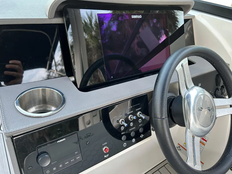 Slide: The Image of 2022 Sea Ray SDX 270 Outboard helm with Simrad display and steering wheel. - 25