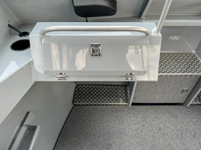 Slide: The Image of 2025 Hewescraft 210 Sea Runner ET interior with storage compartment and diamond plate flooring. - 11