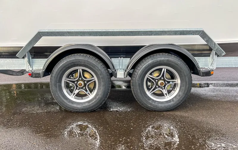 Slide: The Image of 2025 Hewescraft 210 Sea Runner ET trailer wheels on wet pavement. - 21