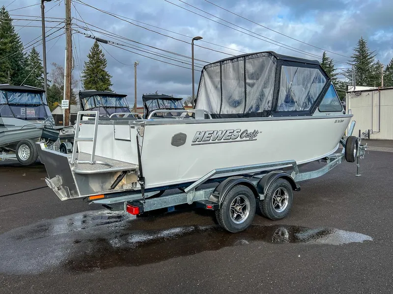 Slide: The Image of 2025 Hewescraft 210 Sea Runner ET boat on trailer, parked outdoors. - 3