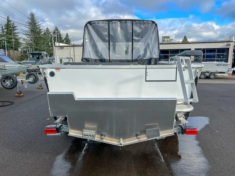 Slide: The Image of 2025 Hewescraft 210 Sea Runner ET boat, rear view, parked outdoors on wet pavement. - 4