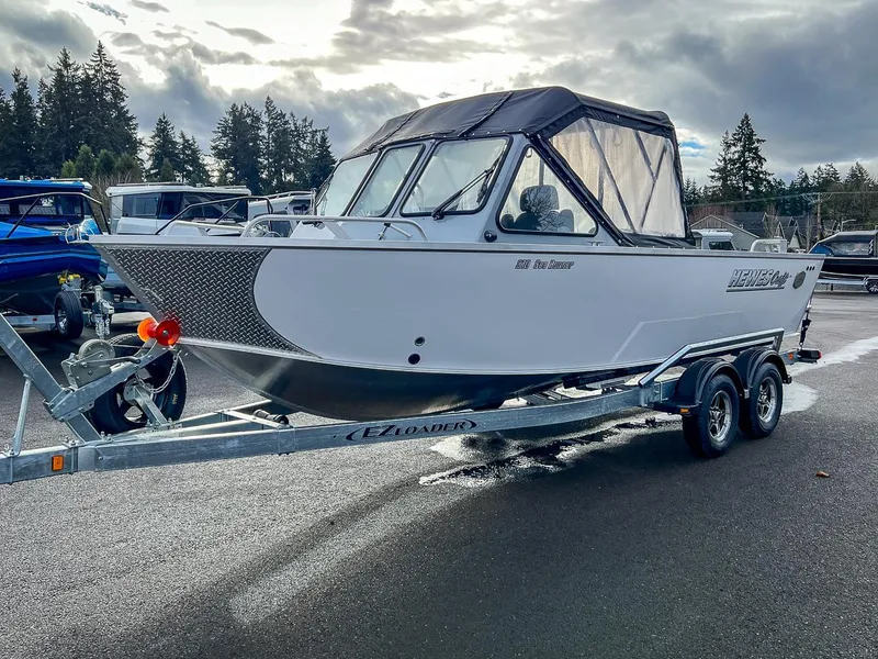 Slide: The Image of 2025 Hewescraft 210 Sea Runner ET boat on trailer, parked outdoors. - 6