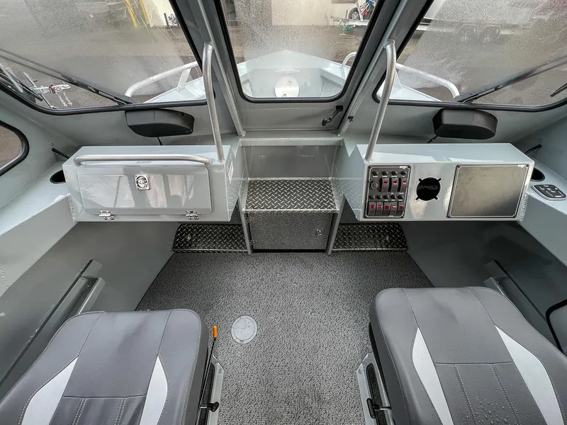 Slide: The Image of Interior of 2025 Hewescraft 210 Sea Runner ET boat, featuring seating and control panel. - 9