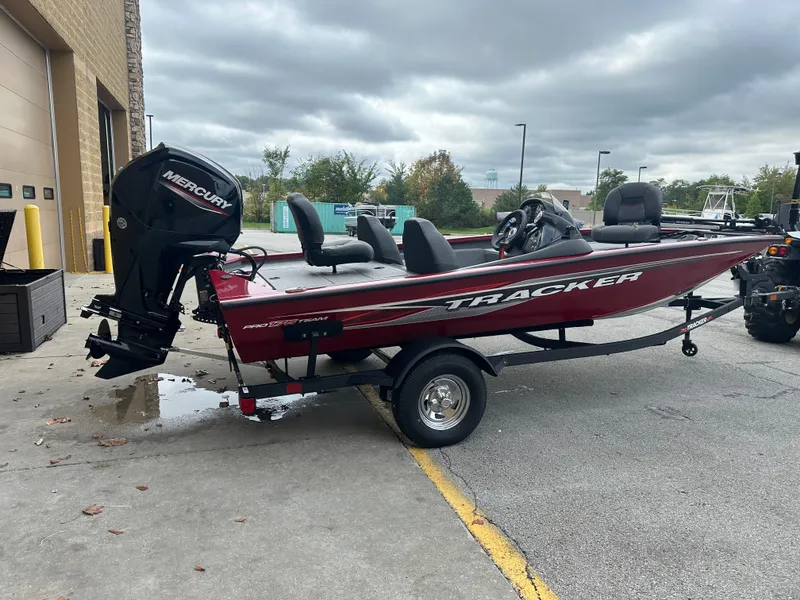 Slide: The Image of 2024 Tracker Pro Team 175 TXW boat with Mercury engine, parked outdoors. - 2
