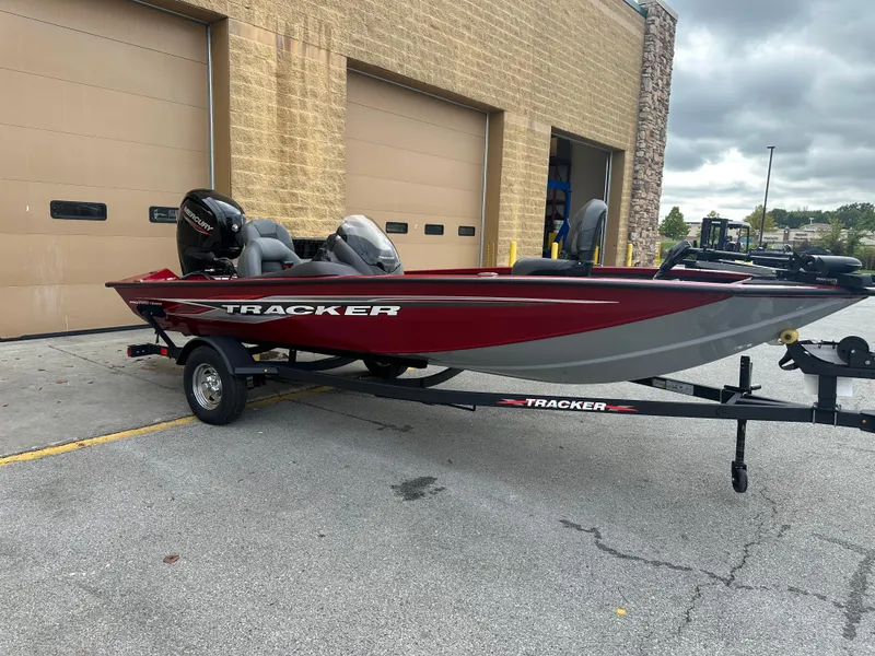 Slide: The Image of 2024 Tracker Pro Team 175 TXW boat on trailer, parked outside a garage. - 3
