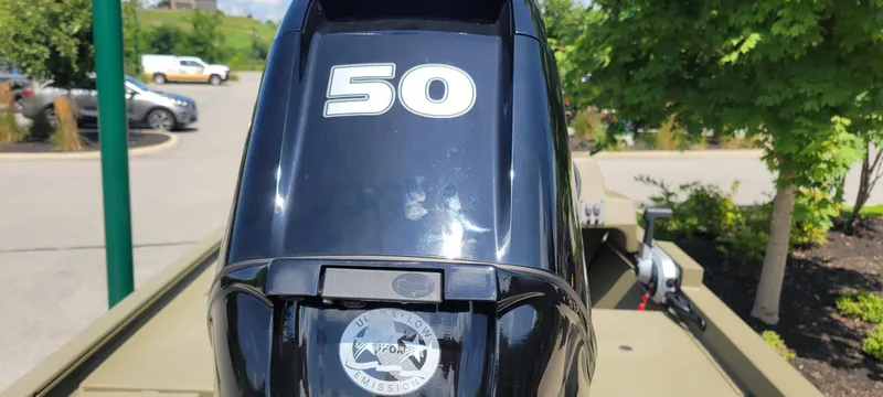 Slide: The Image of 2024 Tracker Grizzly 1648 SC boat with a 50 HP outboard motor in a parking lot. - 3