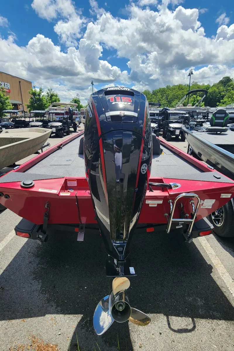 Slide: The Image of 2024 Ranger RT188C boat with outboard motor, parked outdoors under a partly cloudy sky. - 5