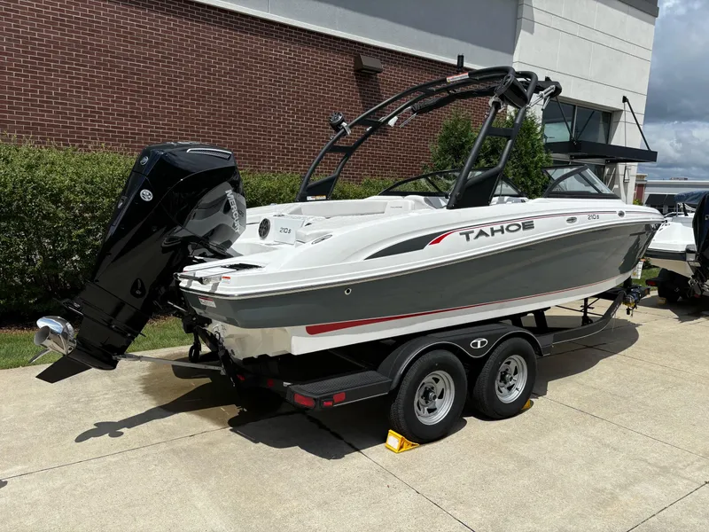 Slide: The Image of 2024 Tahoe 210 S boat on trailer, parked outdoors, featuring sleek design and powerful outboard motor. - 1