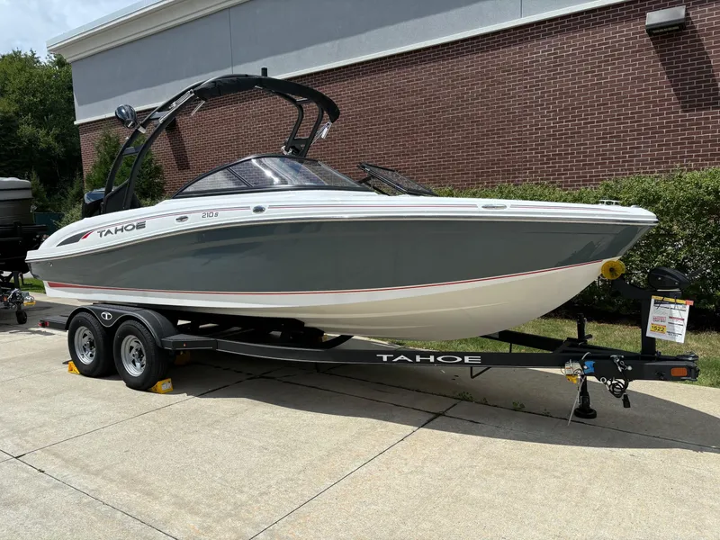 Slide: The Image of 2024 Tahoe 210 S boat on trailer, parked outdoors. - 2