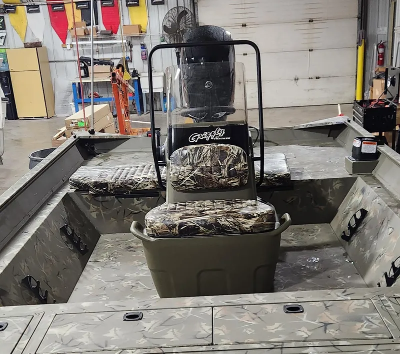 Slide: The Image of 2024 Tracker Grizzly 2072 CC boat with camouflage design in a parking lot. - 3