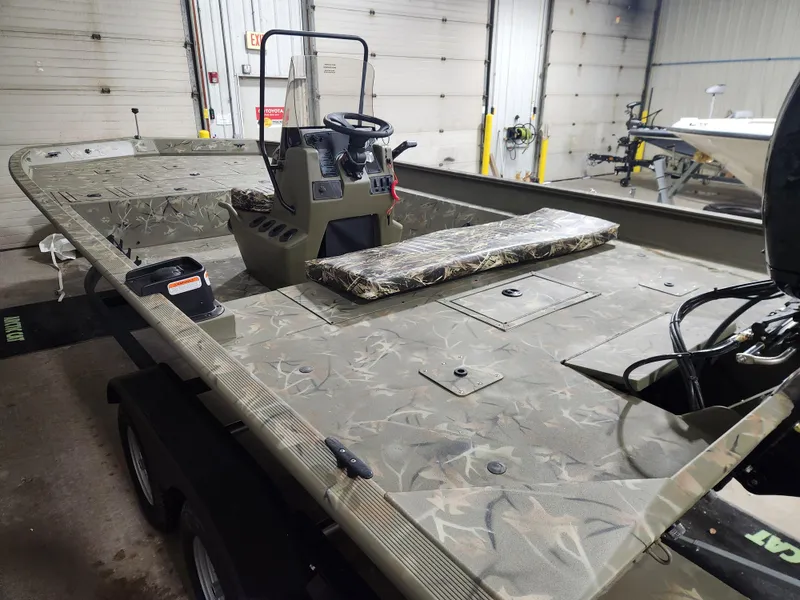 Slide: The Image of 2024 Tracker Grizzly 2072 CC boat with Mercury outboard motor in a garage. - 4