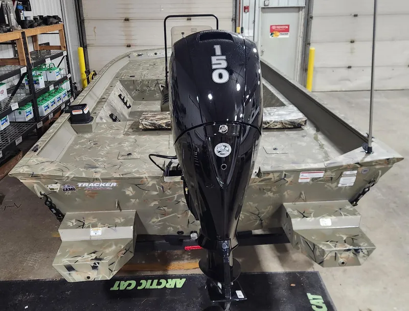 Slide: The Image of 2024 Tracker Grizzly 2072 CC boat with camo pattern interior in a garage. - 6