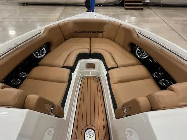 Slide: The Image of 2024 Crownline 270 SS boat interior with tan leather seating and wood flooring. - 2