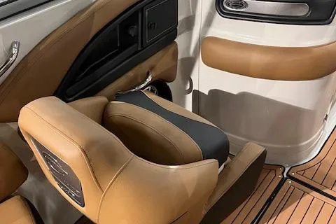 Slide: The Image of 2024 Crownline 270 SS boat interior with tan leather seats and wood flooring. - 4