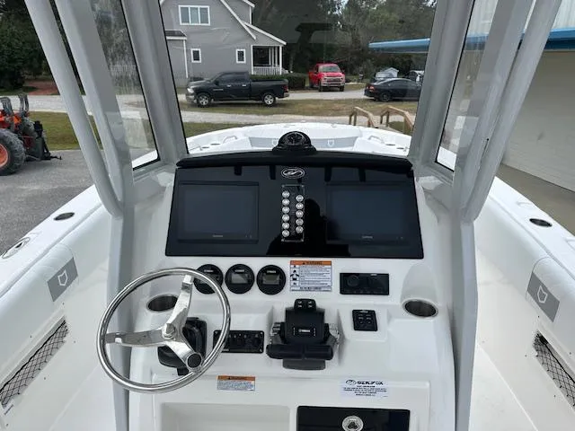 Slide: The Image of 2024 Sea Fox 268 Commander boat dashboard with dual screens and steering wheel. - 6