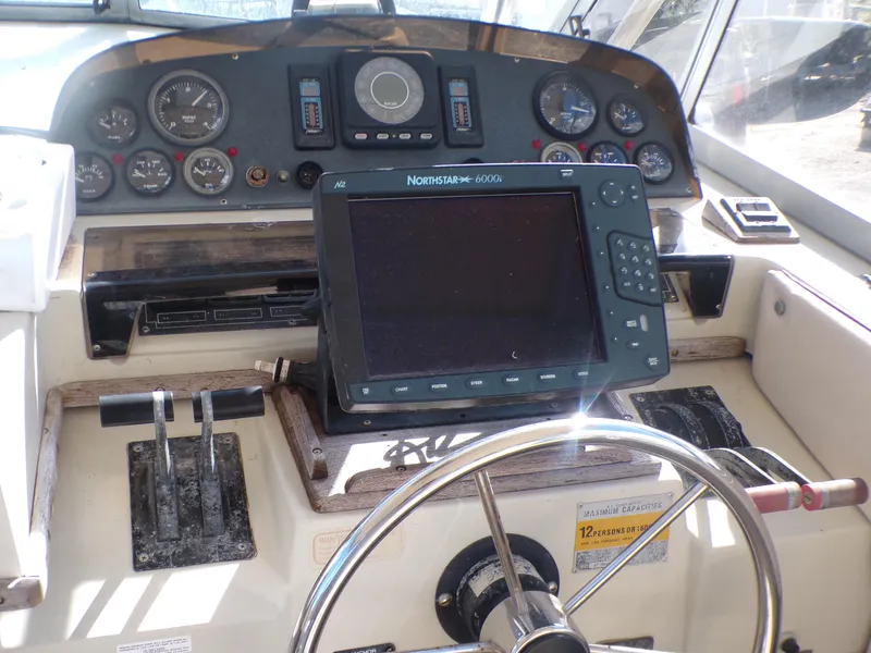 Slide: The Image of 1985 Boston Whaler Dual Console dashboard with steering wheel and navigation equipment. - 13