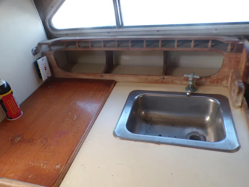 Slide: The Image of 1985 Boston Whaler Dual Console boat interior with sink and wooden counter. - 15