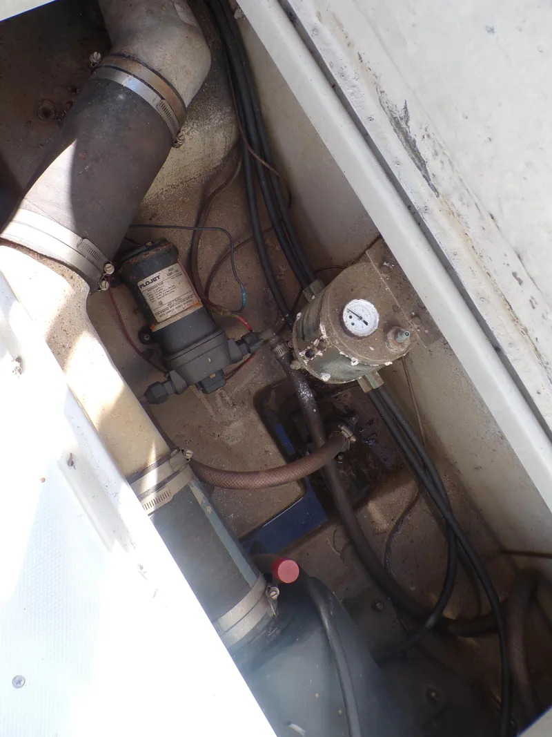 Slide: The Image of 1985 Boston Whaler Dual Console engine compartment with visible hoses and mechanical components. - 8