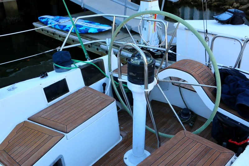 Slide: The Image of Cockpit of a 1985 Baltic 35 sailboat with wooden seating and steering wheel. - 12