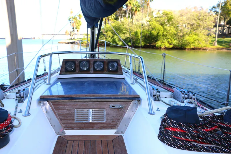 Slide: The Image of 1985 Baltic 35 sailboat cockpit with navigation instruments, docked near lush greenery. - 15