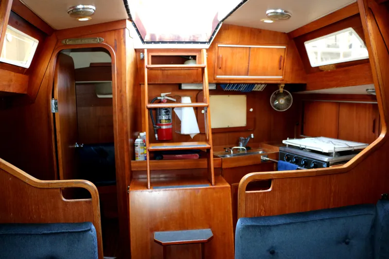 Slide: The Image of Interior of a 1985 Baltic 35 sailboat with wooden cabinetry and compact kitchen. - 26