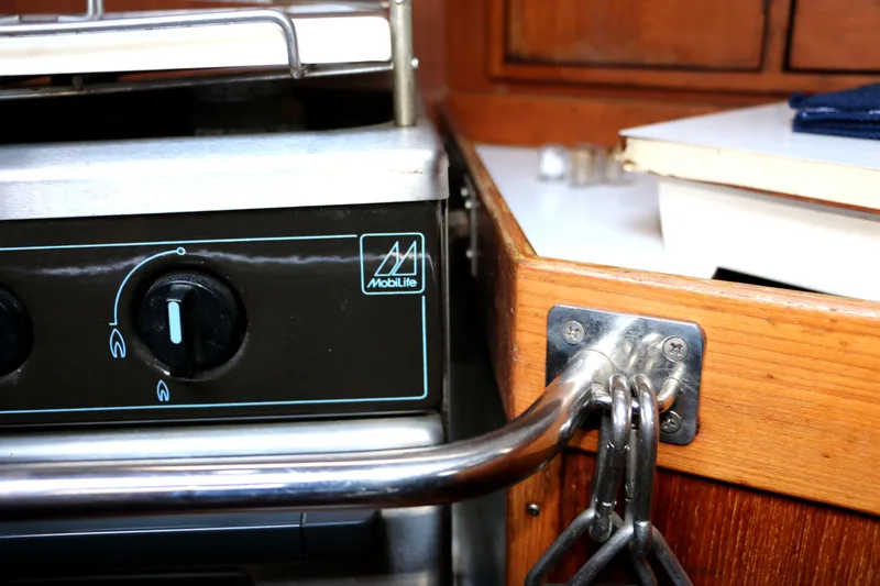 Slide: The Image of Close-up of a 1985 Baltic 35 yacht kitchen stove with Mobillife branding. - 36
