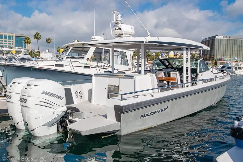The Image of 2018 Axopar 37 Sun-Top boat docked, featuring twin Mercury engines, in a marina setting. - 1