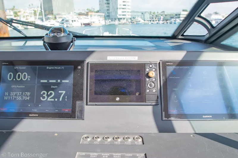 Slide: The Image of Cockpit view of 2018 Axopar 37 Sun-Top with navigation screens and marina background. - 11