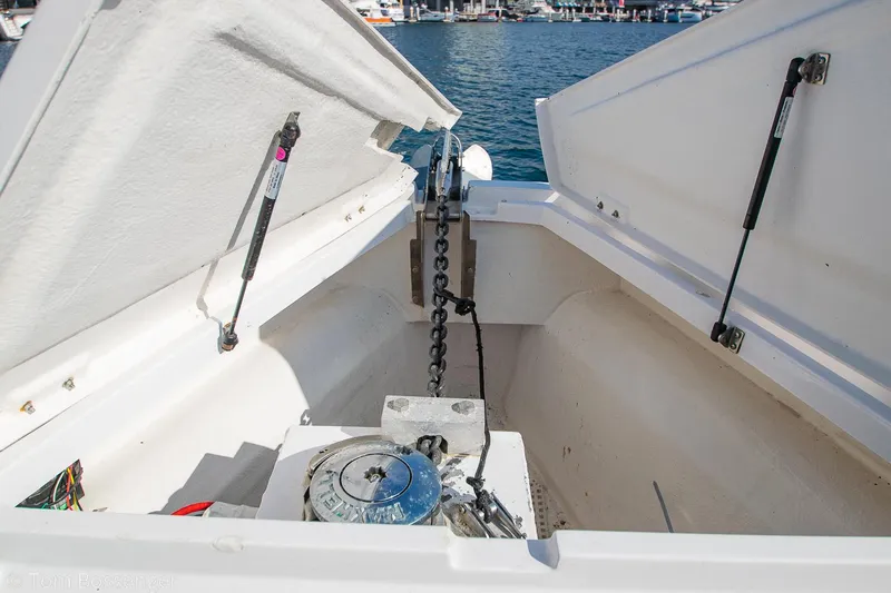 Slide: The Image of 2018 Axopar 37 Sun-Top anchor compartment with open hatches and visible chain mechanism. - 21