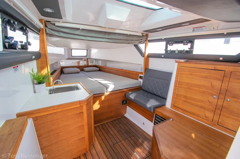 Slide: The Image of 2018 Axopar 37 Sun-Top interior with wood finish, seating, and kitchenette. - 22