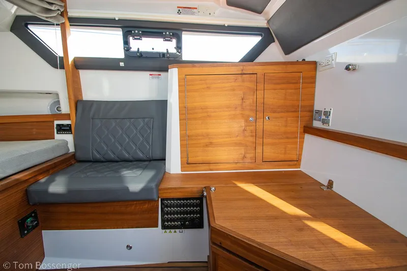 Slide: The Image of 2018 Axopar 37 Sun-Top cabin interior with wood paneling and seating area. - 24