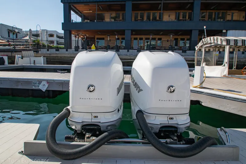 Slide: The Image of Twin Mercury outboard engines on a 2018 Axopar 37 Sun-Top boat docked at a marina. - 28