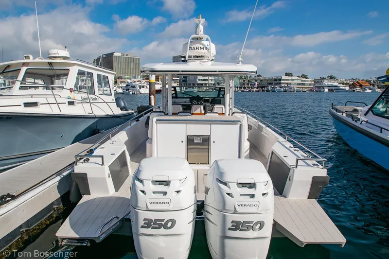 Slide: The Image of 2018 Axopar 37 Sun-Top boat with twin 350 Verado engines docked in a marina. - 3