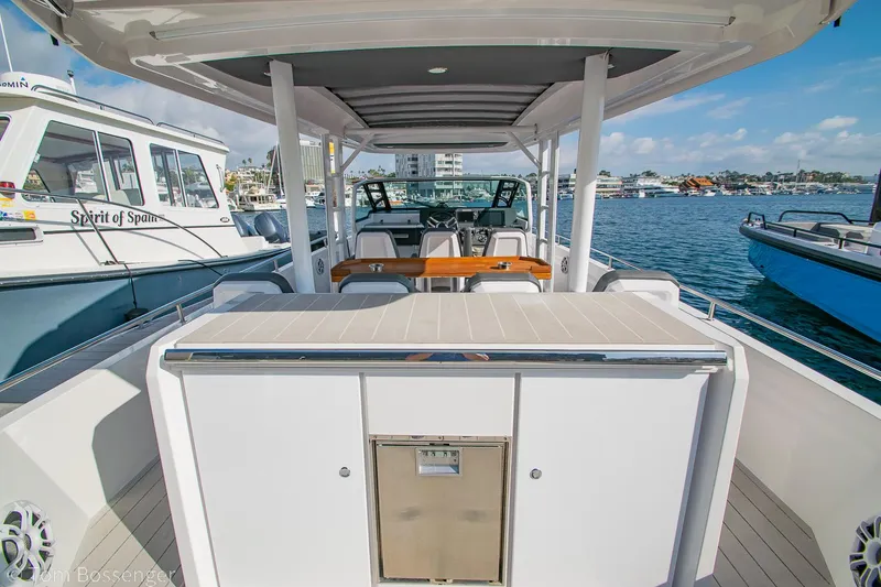 Slide: The Image of 2018 Axopar 37 Sun-Top boat docked, featuring spacious deck and modern design. - 4