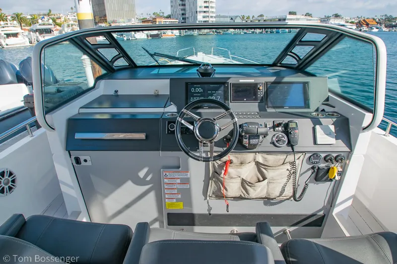 Slide: The Image of 2018 Axopar 37 Sun-Top boat cockpit with steering wheel and navigation equipment. - 8