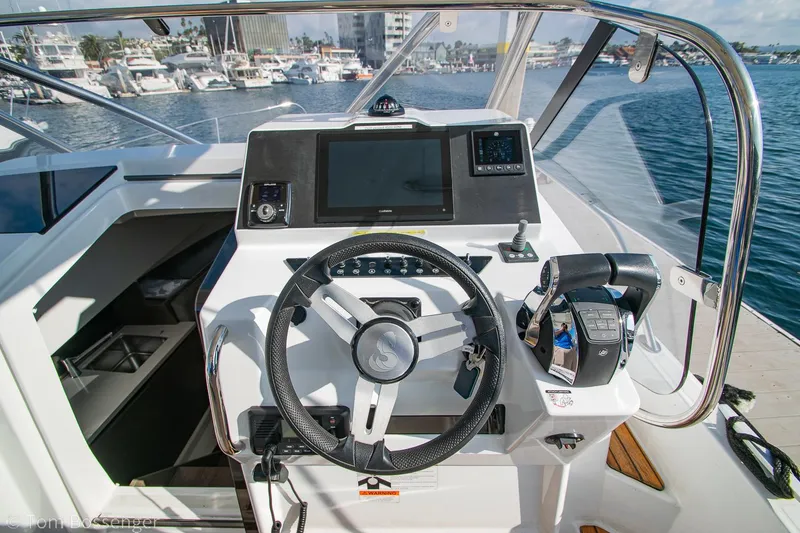 Slide: The Image of 2022 Beneteau Flyer 9 helm with modern controls and navigation, docked at marina. - 10